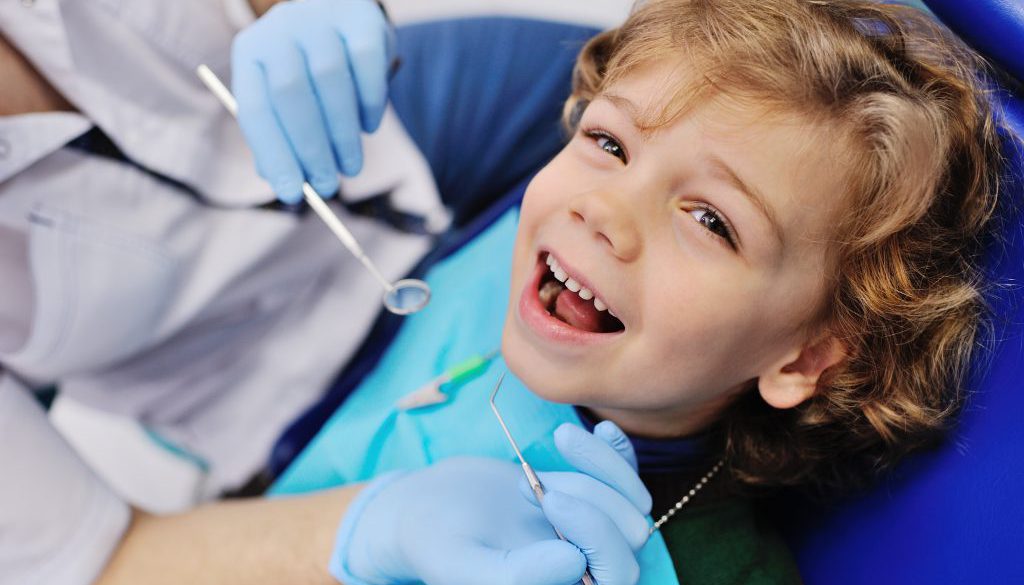 Male dentist examines a young patient